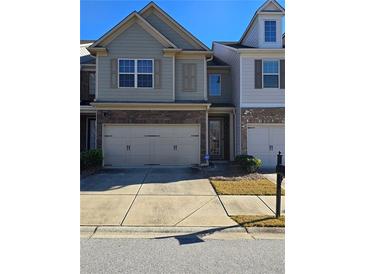 Charming two-story townhome featuring stone accents and a two-car garage at 2293 Chancery Mill Ln, Buford, GA 30519