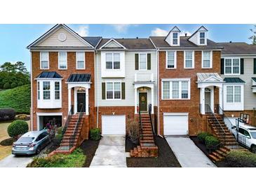 Charming townhome with brick accents, one-car garage, and well-maintained landscaping at 236 Balaban Cir, Woodstock, GA 30188