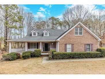 Charming brick home with a covered front porch and well-manicured landscaping at 1070 Thornwood Cir, Covington, GA 30016