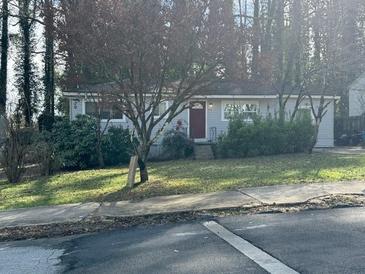 Charming single-story home features a well-kept lawn and inviting curb appeal in a serene, wooded setting at 3346 Delmar Nw Ln, Atlanta, GA 30331