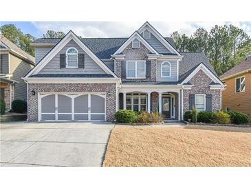 Charming two-story brick home with a well-manicured lawn, gray shutters, and a two-car garage at 55 Little Barley Ln, Grayson, GA 30017