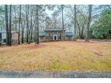Charming two-story home with traditional design and mature trees in a landscaped yard at 1838 Nicole Ln, Lithonia, GA 30058
