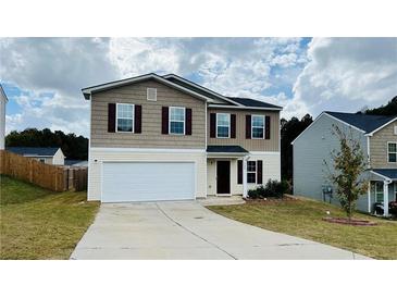 Two story home featuring a two car garage and neutral exterior paint at 720 Dove Tree Ln, Social Circle, GA 30025