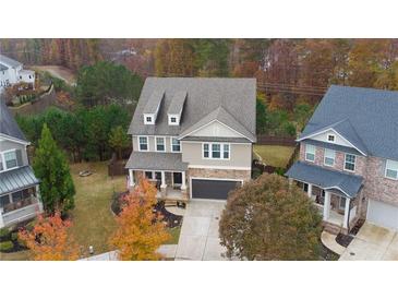 Beautiful two-story home featuring stone accents, neutral siding, an attached garage, and a well-maintained front yard at 322 Kells Ct, Woodstock, GA 30188