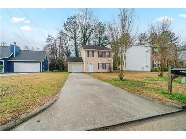 Charming two-story home featuring a classic design, single car garage, and long driveway at 821 Stonebridge Park Cir, Lithonia, GA 30058