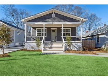 Charming home featuring a covered front porch, gray siding, and a well-maintained green lawn at 260 Miller Reed Se Ave, Atlanta, GA 30315