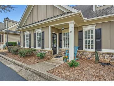 Charming front entrance of home with stone accents, manicured landscaping, and inviting blue rocking chair at 625 Aunt Lucy Sw Ln # 34/19, Smyrna, GA 30082