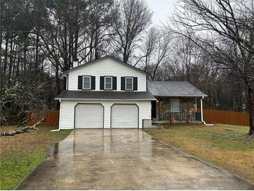 Charming home featuring a two-car garage, neutral siding, and a welcoming front yard at 1281 Bugle Ct, Hampton, GA 30228