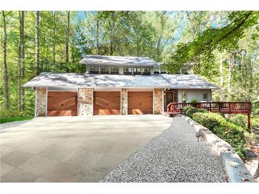 Secluded three-car garage home featuring stone accents and well-maintained landscaping at 4867 Township Trce, Marietta, GA 30066