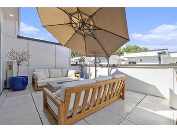 Inviting rooftop patio with comfortable seating, umbrella, and modern fire pit feature, perfect for outdoor relaxation at 1145 Kirkwood Se Ave # 4, Atlanta, GA 30316