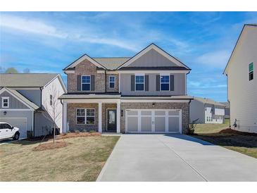 Charming two-story home featuring a brick and gray facade, well-manicured lawn, and a two-car garage at 706 Bristol Dr, Loganville, GA 30052