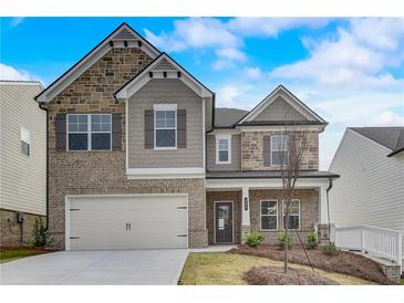 Charming two-story home with brick and stone accents, attached two-car garage, and manicured front yard at 508 Clayborne Way, Loganville, GA 30052