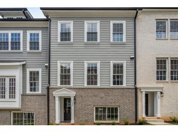 Attractive townhouse with a gray facade and a charming brick base, showcasing classic architectural details at 3165 Dogwood Dr # 106, Hapeville, GA 30354