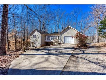 Charming one-story home with an attached garage and enclosed porch, nestled among mature trees and a long driveway at 2370 Huckleberry Ln, Lithia Springs, GA 30122