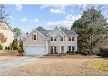 Charming two-story home with a well-maintained lawn, two car garage, and a welcoming entrance at 2030 Brook Meadow Dr, Alpharetta, GA 30005