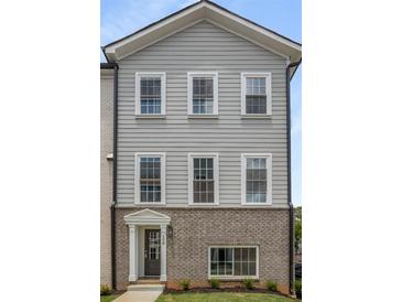 Charming two-story townhome exterior featuring gray siding, brick accents and white-framed windows at 3165 Dogwood Dr # 108, Hapeville, GA 30354