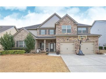 Charming two-story brick home featuring a two-car garage, well-manicured lawn, and a welcoming front porch at 58 Ashbury Cir, Dallas, GA 30157