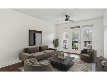 Bright living room with hardwood floors, modern furnishings, and access to a private balcony with outdoor seating at 840 United Se Ave # 411, Atlanta, GA 30312