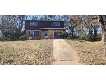 Two-story home with a brick facade on the lower half and siding on the upper half and an attached one car garage at 3747 Southland Ct, Atlanta, GA 30344