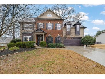 Charming two-story home with a brick and siding exterior, a well-maintained lawn, and mature landscaping at 2295 Hemrick Rd, Cumming, GA 30041