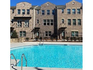 Stunning community pool with a view of modern brick townhomes on a sunny day at 3152 Quinn Pl, Atlanta, GA 30341