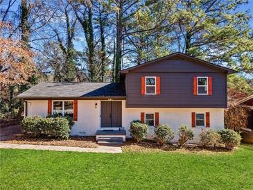 Charming two-story home with a brick exterior, well-maintained lawn, and dark shutters with orange accents at 2814 Lloyd Rd, Decatur, GA 30034