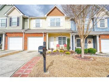 Charming townhome featuring a well-manicured front yard and attached one car garage at 3068 Cedar Glade Ln, Buford, GA 30519