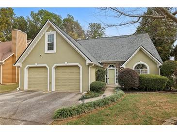 Charming home featuring a two-car garage and lush front yard landscaping at 4710 Vineyard Se Ct, Smyrna, GA 30082