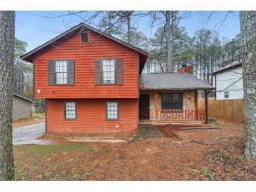 Cozy two-story home with red siding, complementary brown shutters, and a charming stone-accented front porch at 1057 Forest Path, Stone Mountain, GA 30088