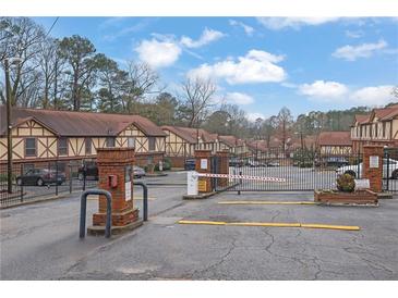 Gated community entrance featuring brick pillars and well-maintained landscaping for enhanced security and curb appeal at 3236 Abbeywood Dr, Decatur, GA 30034