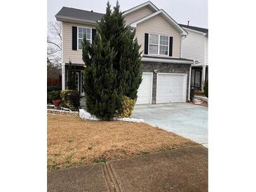 Charming two-story home with stone accents, a two-car garage, and a well-manicured lawn at 7248 Mountain Laurel Way, Stockbridge, GA 30281