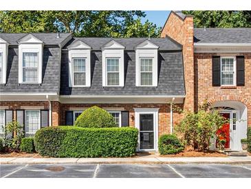 Charming townhome with brick facade, dormer windows, and manicured landscaping at 5 Spring Green Pl, Atlanta, GA 30318