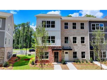 Beautiful townhome with a mix of brick and siding and a well-manicured lawn at 5463 Blossomwood Sw Trl, Mableton, GA 30126