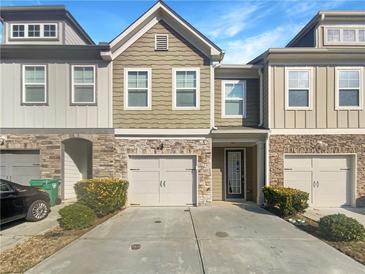 Charming townhome featuring a stone facade, attached garage, and well-maintained landscaping at 2693 Avanti Way, Decatur, GA 30035