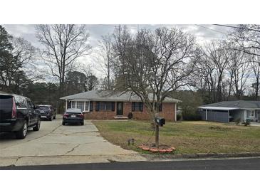 Charming brick home featuring a well-kept lawn and a paved driveway at 724 Camelot Way, Norcross, GA 30071