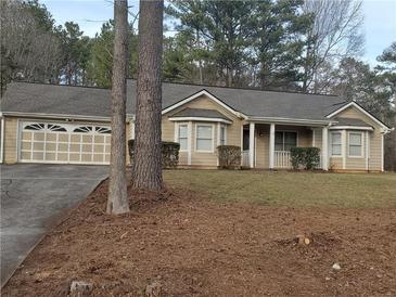 Charming single-story home with a well-manicured lawn, attached two car garage, and a welcoming front porch at 130 Willow Shoals Dr, Covington, GA 30016