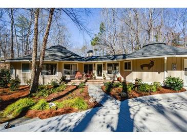 Charming home with unique architectural details, landscaped front yard, stone pathway and round rooflines at 100 Silverbell Ct, Roswell, GA 30075