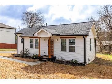 Charming renovated home with new roof, white siding, wood accents, and well-manicured yard at 1466 Venetian Sw Dr, Atlanta, GA 30311