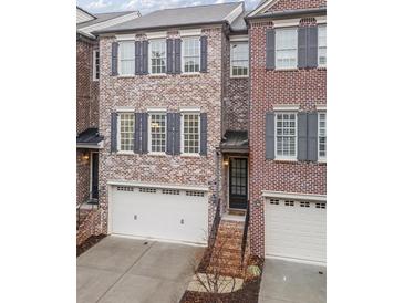 Charming brick townhome with a two-car garage and beautiful architectural details at 145 Rose Garden Ln, Alpharetta, GA 30009