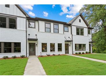 Charming new construction townhomes with white brick and siding, complemented by lush green lawns and professional landscaping at 1322 Parc Bench Rd, Atlanta, GA 30316