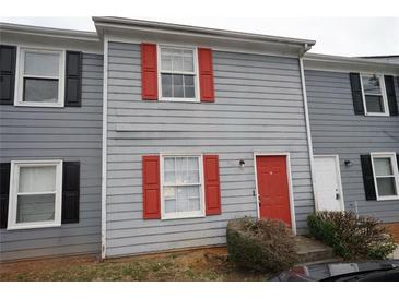 Charming townhouse featuring gray siding and vibrant red door and window shutters at 2660 Evans Mill Dr, Lithonia, GA 30058