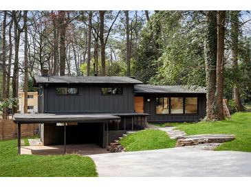 Contemporary exterior with dark siding, carport, stone walkway, and natural landscaping at 3637 Eaglerock Dr, Atlanta, GA 30340