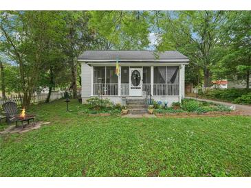 Charming home featuring a screened porch, small fire pit and lush greenery at 1610 Elm Ne St, Conyers, GA 30012