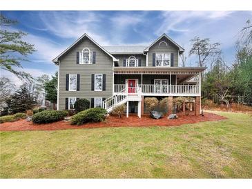 Charming two-story home with covered porch, a red door, and a beautifully landscaped front yard at 2691 Jamerson Rd, Marietta, GA 30066