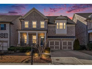 Charming brick home featuring a two-car garage and welcoming front porch at 11330 Easthaven Pl, Johns Creek, GA 30097