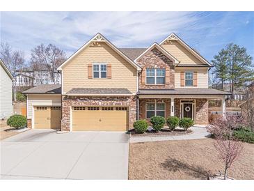 Charming two-story home with a manicured front lawn and a welcoming covered porch and a three-car garage at 965 Mulberry Bay Dr, Dacula, GA 30019