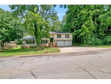Charming split-level home with a well-maintained lawn and lush trees in a quiet neighborhood at 467 Pineburr Ln, Stone Mountain, GA 30087