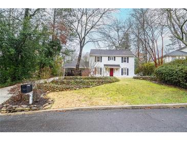 Charming two-story home with a landscaped front yard, complemented by black shutters and a red front door at 970 Winding Creek Trl, Atlanta, GA 30328