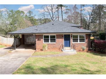 Charming brick home featuring a well-maintained lawn, a quaint carport, and a welcoming blue front door at 412 E Pharr Rd, Decatur, GA 30030