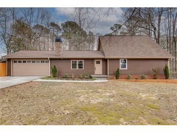 Charming home with a neatly landscaped front yard, attached garage and cozy facade at 120 Arrowood Ln, Alpharetta, GA 30009